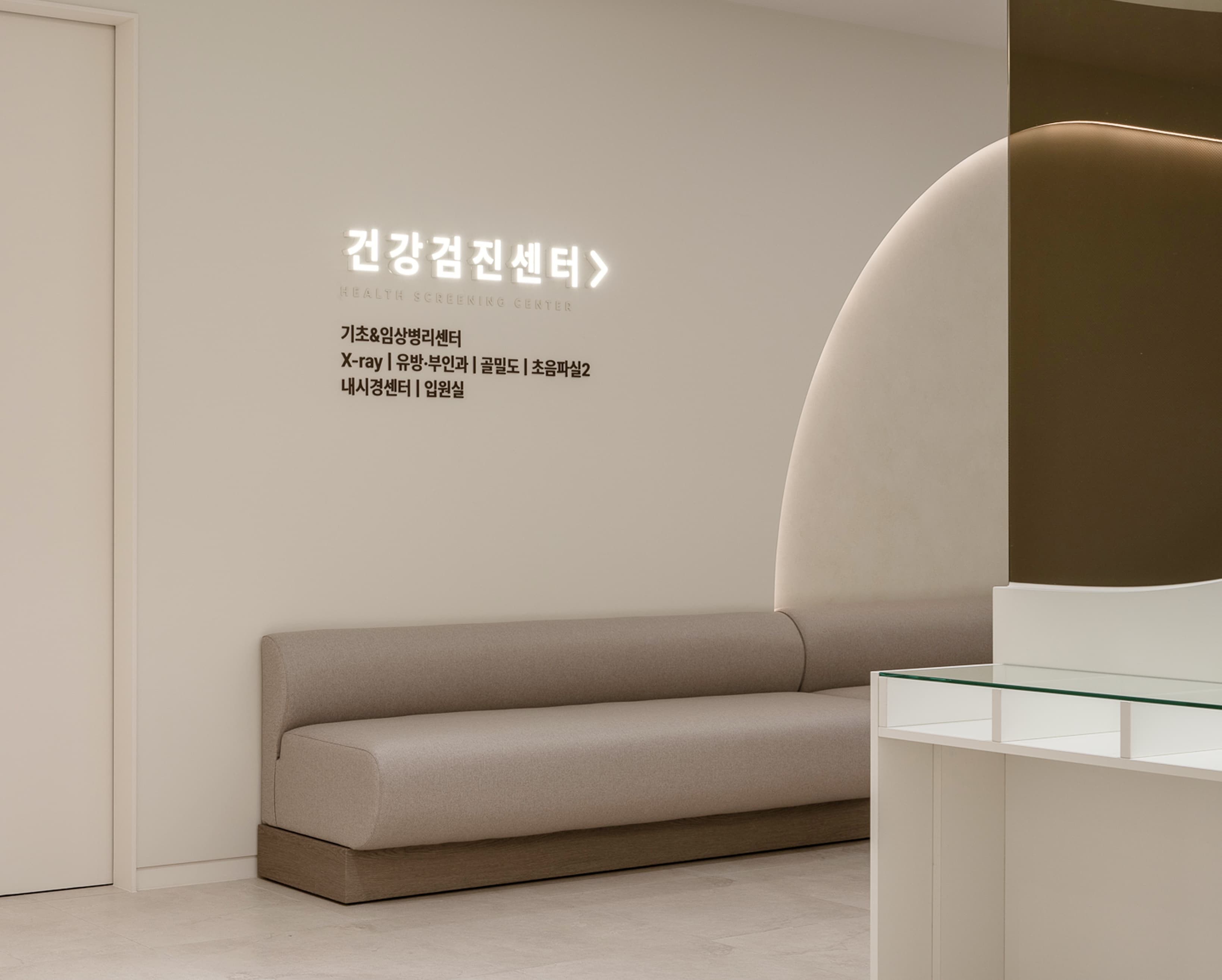 안양프라임메디의원 5대암검진센터 대기 공간. 안내 표지판과 편안한 소파 좌석이 함께 배치되어 있어, 검진 전 환자가 안내를 확인하고 대기할 수 있는 구조를 보여준다.